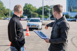 Driving instructor explaining a manoeuvre to a learner driver after a lesson in Manchester